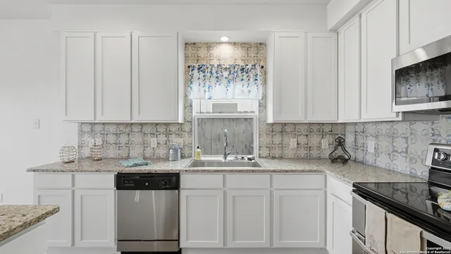 a kitchen with stainless steel appliances granite countertop a sink stove and cabinets