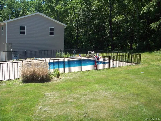 a view of house with backyard and a slide