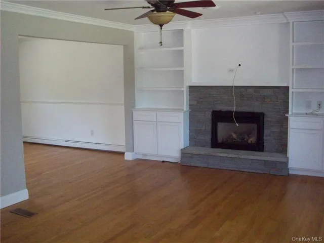 a living room with a fireplace and wooden floor