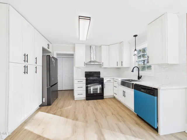 a kitchen with granite countertop a stove top oven and refrigerator