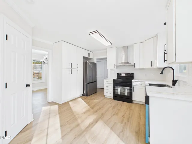 a kitchen with granite countertop a refrigerator and a stove top oven