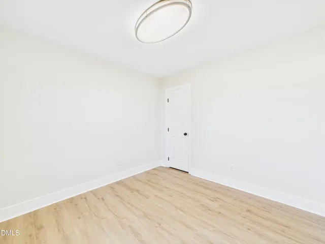 a view of a room with wooden floor and white walls