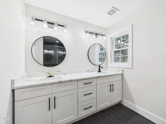 a bathroom with 2 sink and a mirror