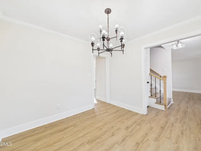 a view of a room with wooden floor staircase and a chandelier