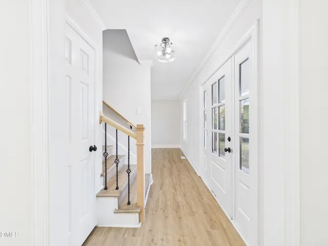 a view of a hallway with wooden floor and staircase