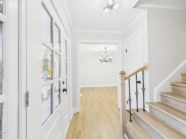 a view of a hallway with wooden floor and staircase