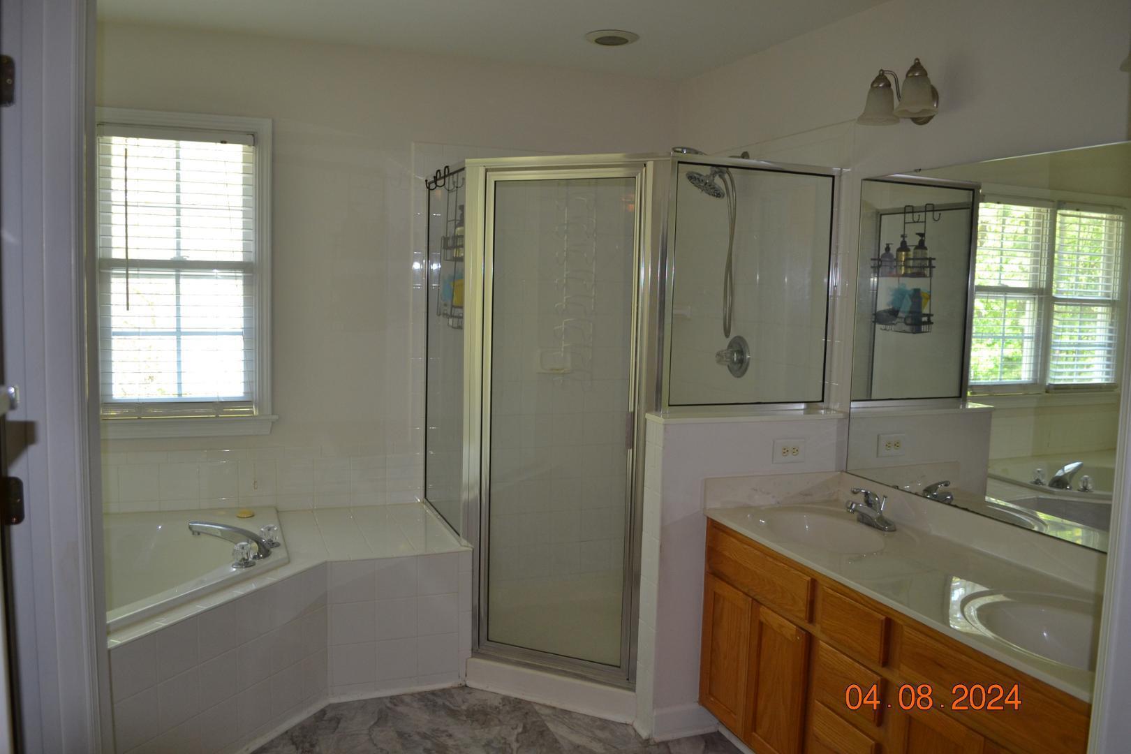 4506 Mistiflower Drive Raleigh, NC 27606 - Photo 24 of 27 a bathroom with a tub sink shower and mirror