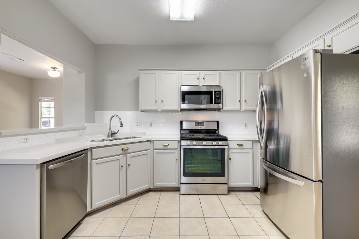 1504 East 19th Street Georgetown, TX 78626 - Photo 5 of 27 a kitchen with stainless steel appliances granite countertop a refrigerator sink and stove