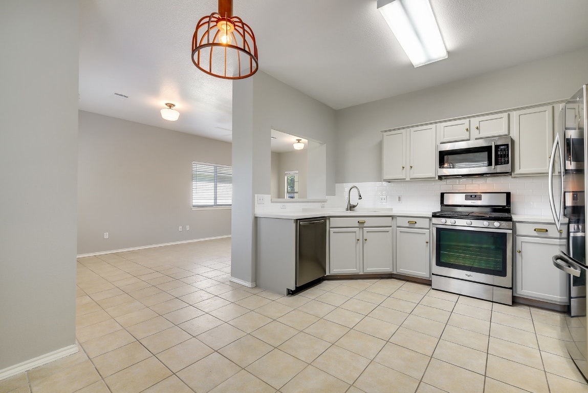 1504 East 19th Street Georgetown, TX 78626 - Photo 7 of 27 a kitchen with a sink cabinets and stainless steel appliances