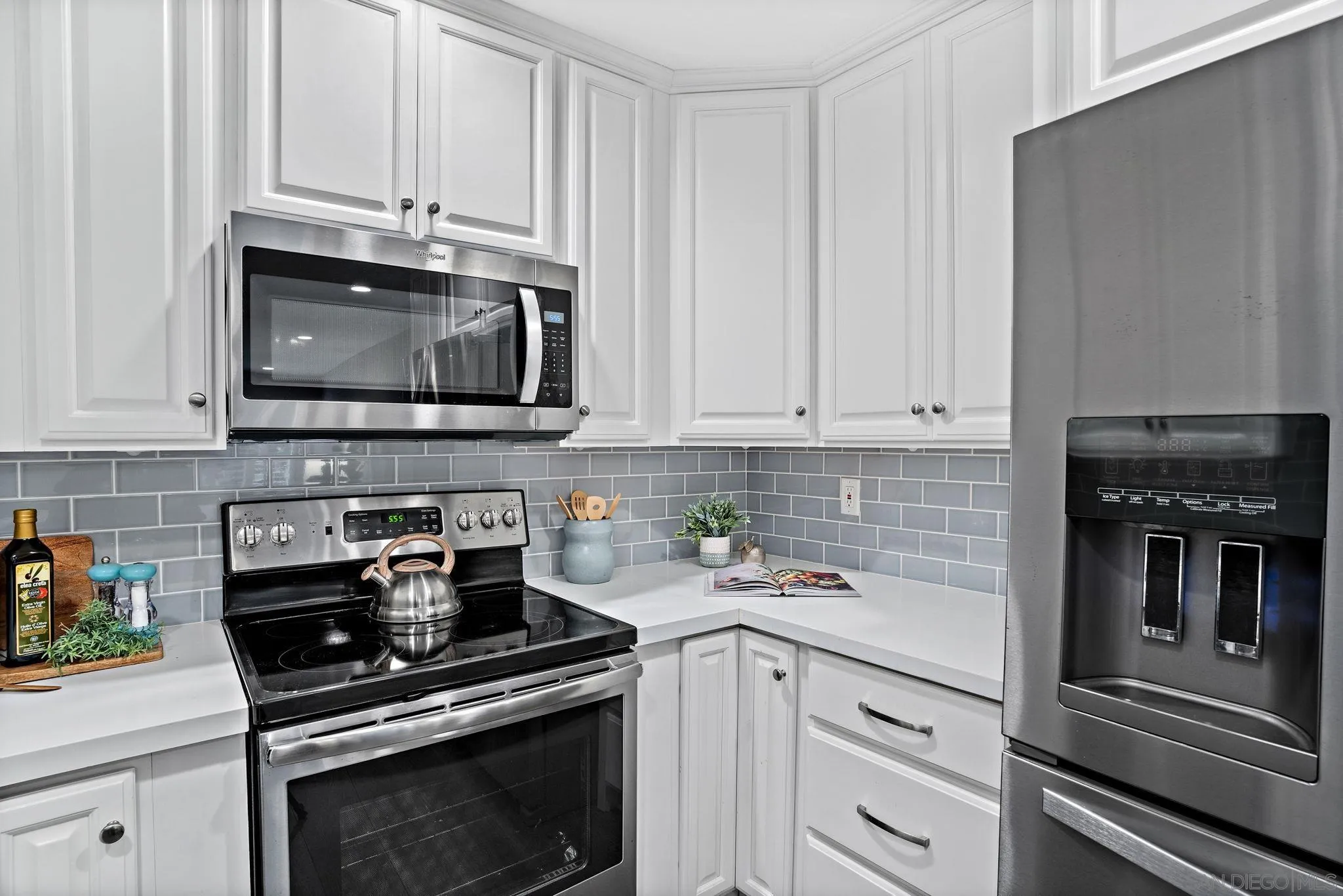 5705 Friars Road, Unit 8 San Diego, CA 92110 - Photo 4 of 26 a kitchen with granite countertop white cabinets and stainless steel appliances