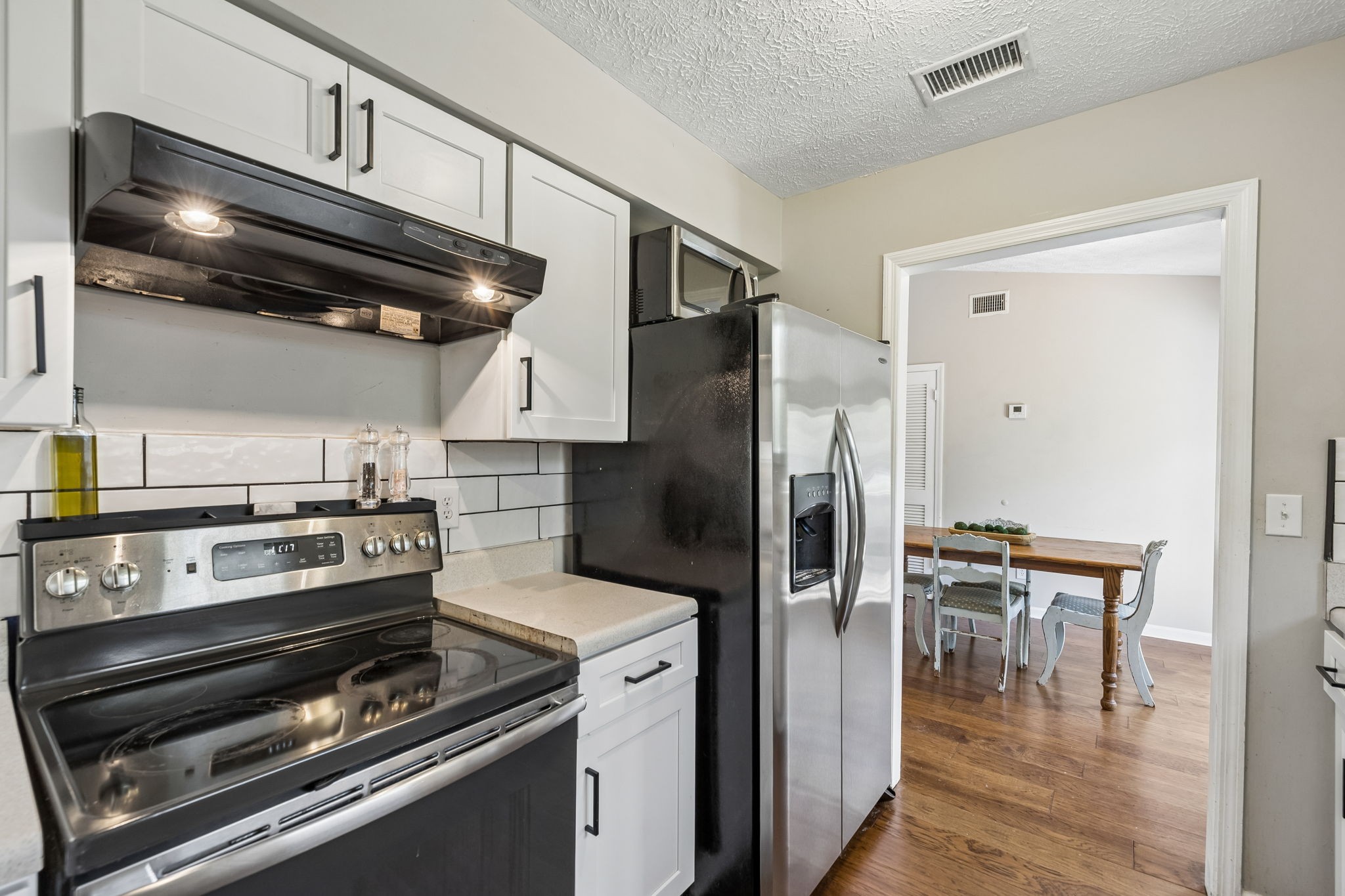 8617 Maple Street Murfreesboro, TN 37129 - Photo 22 of 31 a kitchen with wooden cabinets stainless steel appliances and a dining table