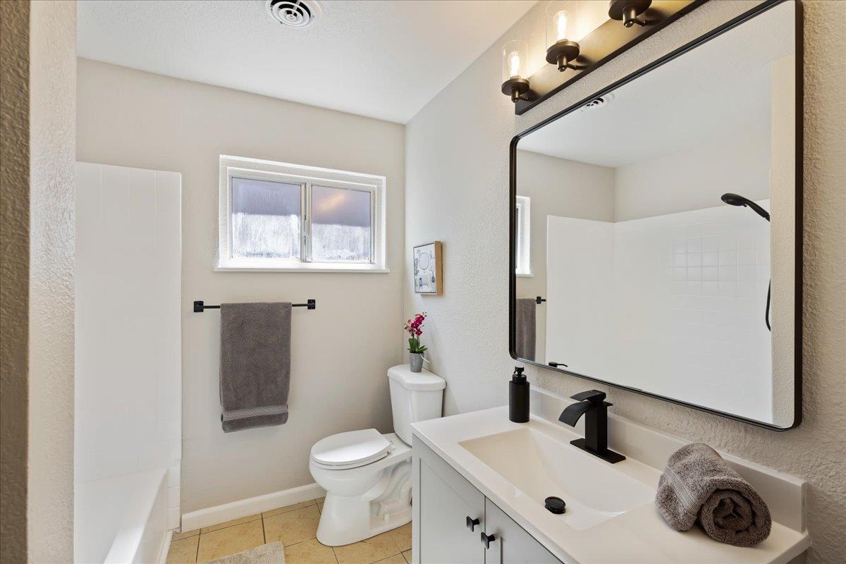 231 Pinole Avenue Rodeo, CA 94572 - Photo 13 of 26 a bathroom with a sink mirror vanity and toilet