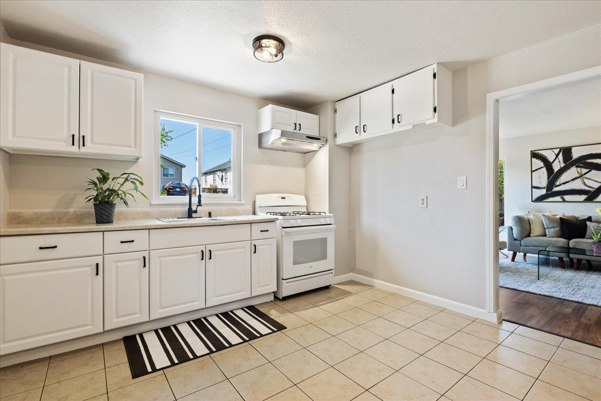 231 Pinole Avenue Rodeo, CA 94572 - Photo 8 of 26 a kitchen with white cabinets and white appliances