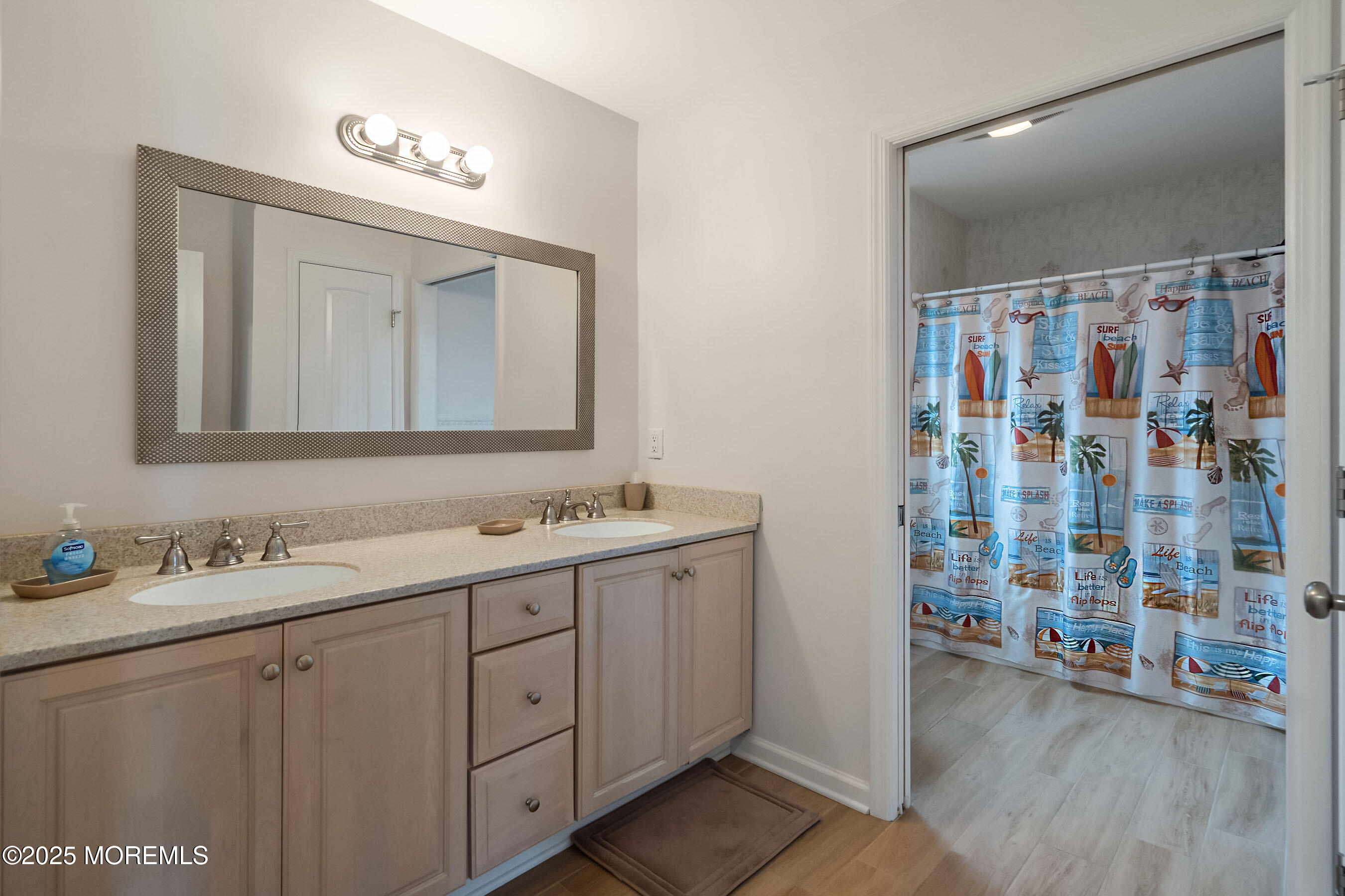 21 Magee Avenue Lavallette, NJ 08735 - Photo 19 of 25 a bathroom with a double vanity sink a mirror a shower and a bathtub