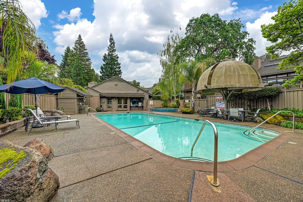 7650 Pineridge Road Fair Oaks, CA 95628 - Photo 64 of 67 a view of a swimming pool with a table and chairs under an umbrella