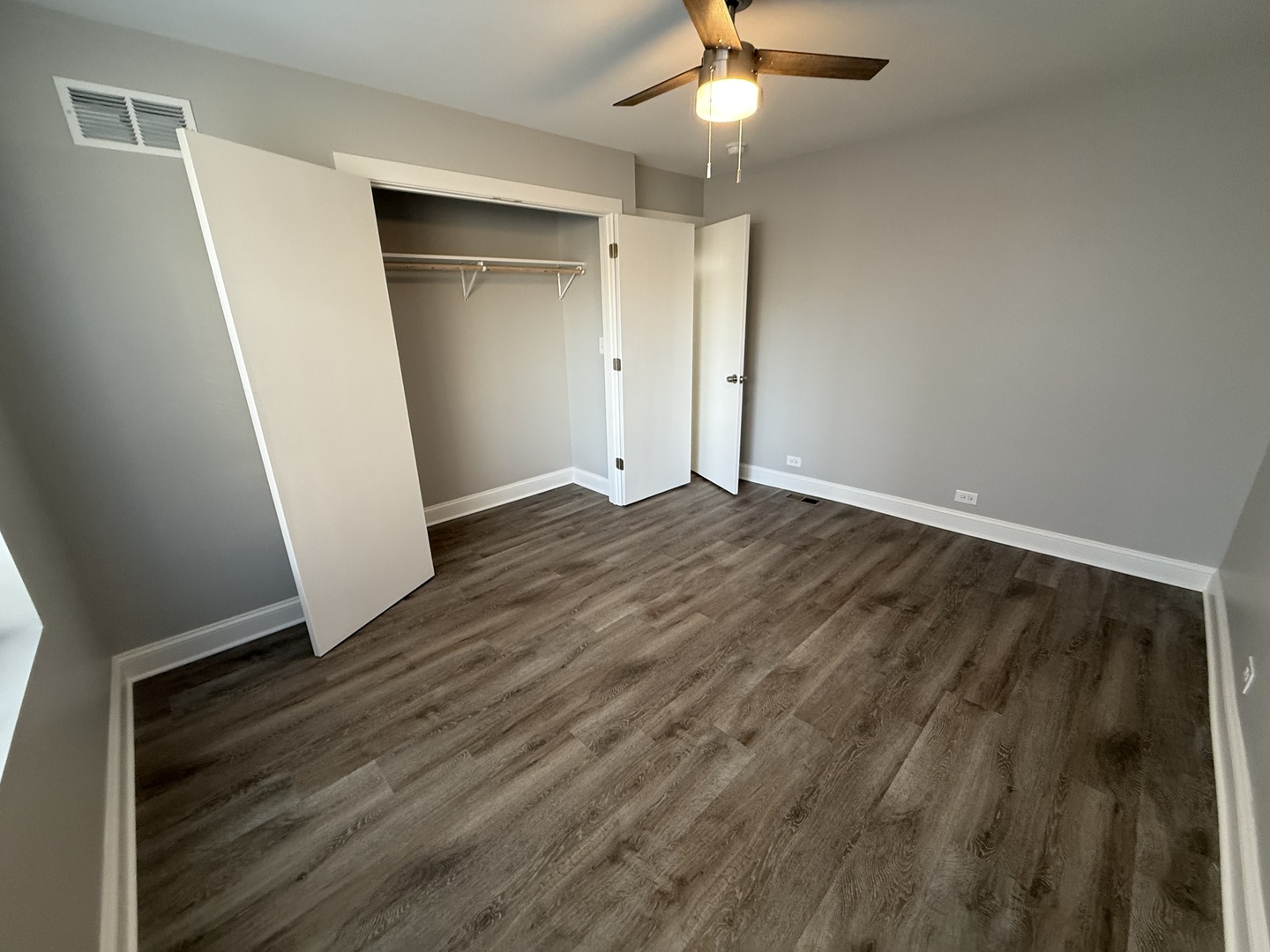 744 West Gordon Terrace, Unit 312 Chicago, IL 60613 - Photo 11 of 11 an empty room with wooden floor and a ceiling fan