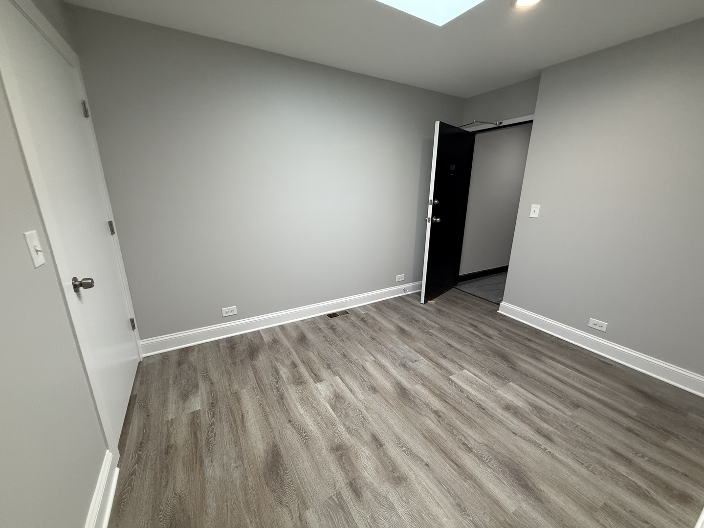 744 West Gordon Terrace, Unit 312 Chicago, IL 60613 - Photo 8 of 11 a view of an empty room with wooden floor and a window