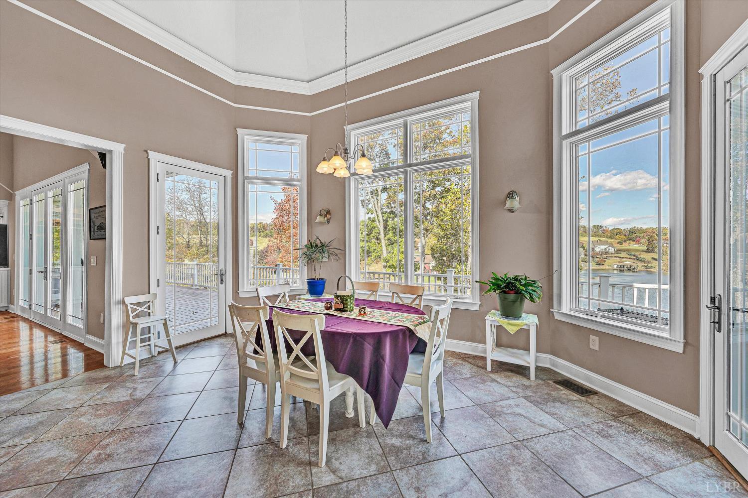 803 Compass Cove Circle Moneta, VA 24121 - Photo 24 of 92 a view of a dining room with furniture large windows and wooden floor