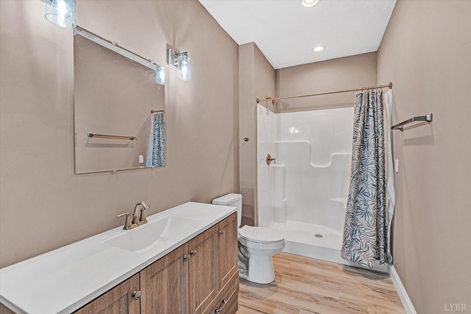 803 Compass Cove Circle Moneta, VA 24121 - Photo 51 of 92 a bathroom with a double vanity sink toilet mirror and shower