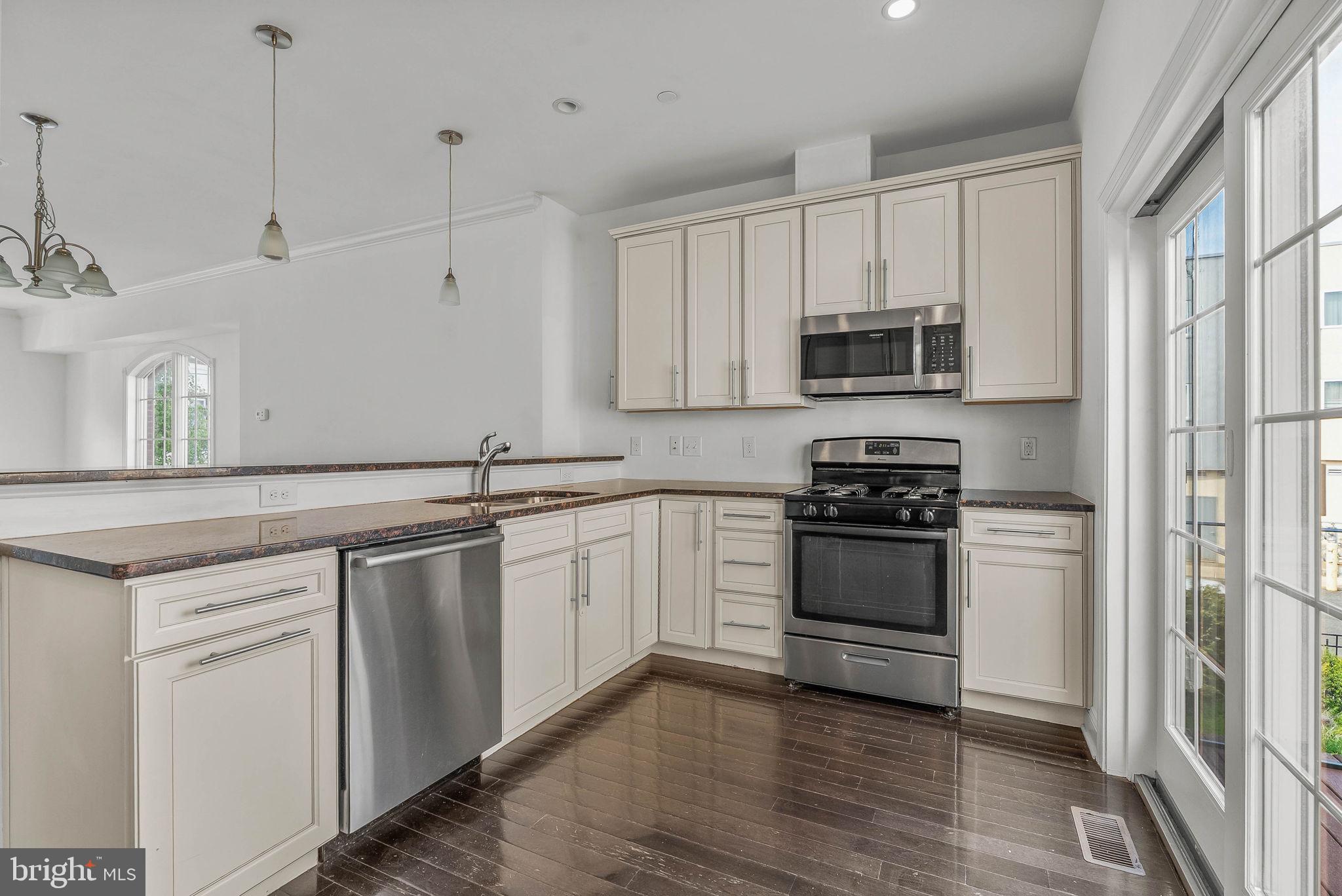 1015 North 3rd Street, Unit H Philadelphia, PA 19123 - Photo 8 of 27 a kitchen with stainless steel appliances granite countertop a stove and a sink