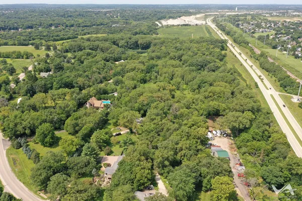 an aerial view of residential houses with outdoor space and trees