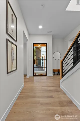 a view of an empty room with wooden floor and windows