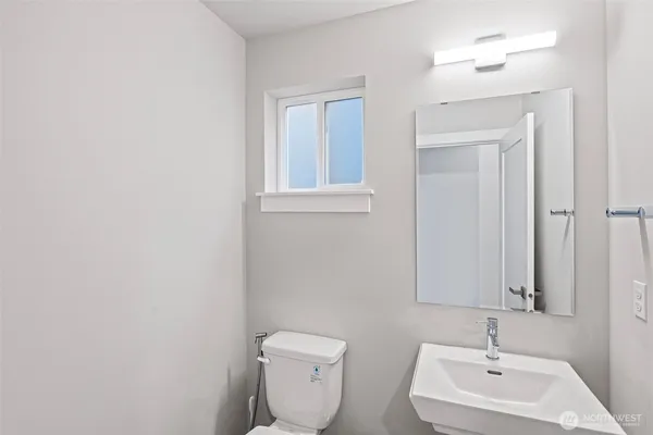 a bathroom with a toilet a sink and mirror