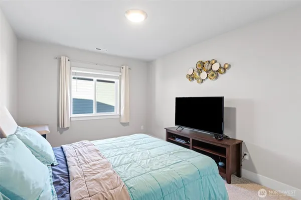 a bedroom with a bed and a flat screen tv