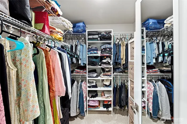 a view of walk in closet with clothes