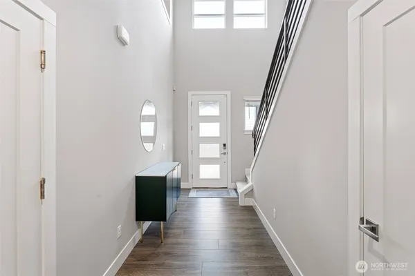 a view of a hallway with wooden floor and staircase