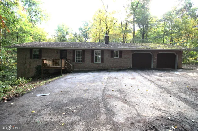 a backyard of a house with barbeque oven and trees