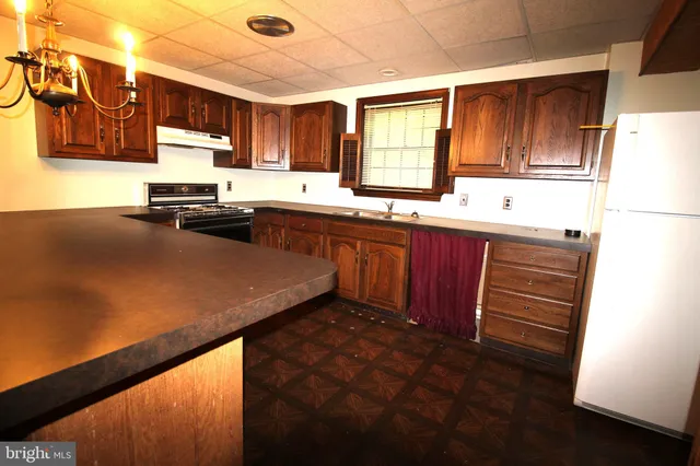 a kitchen with wooden cabinets sink and window