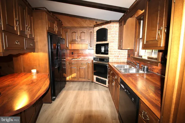 a kitchen with stainless steel appliances granite countertop sink stove top oven and cabinets