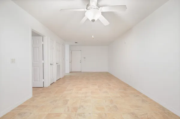 an empty room with chandelier fan