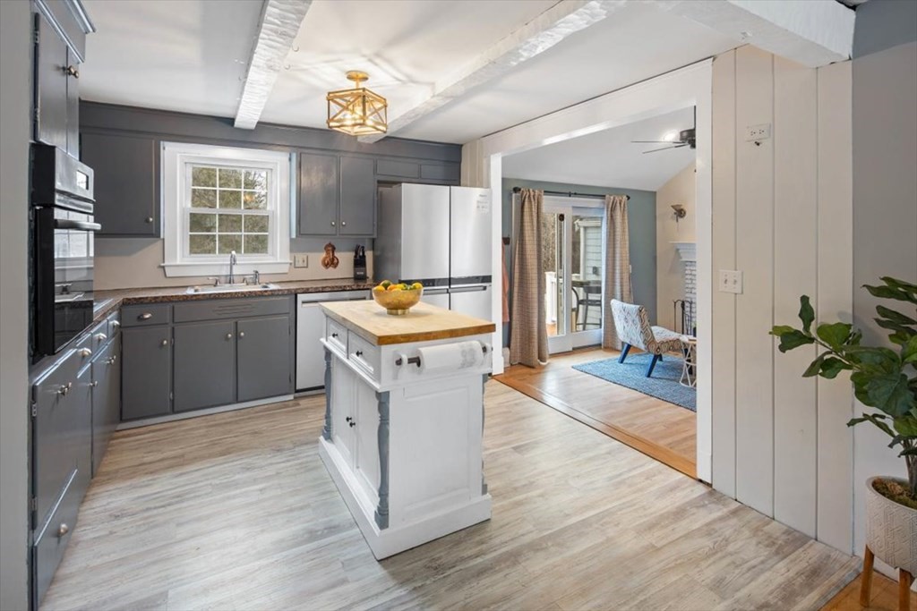 53 Winter Street Kingston, MA 02364 - Photo 10 of 28 a kitchen with a stove a sink wooden floor and a refrigerator