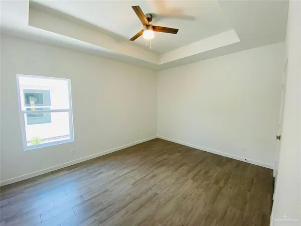 an empty room with a window and ceiling fan