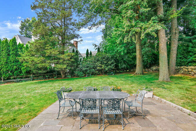 105 Lockwood Road Riverside, CT 06878 - Photo 3 of 22 a view of a backyard with table and chairs potted plants and large tree