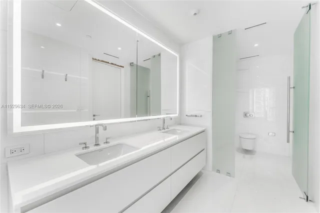 a bathroom with a double vanity sink mirror and toilet