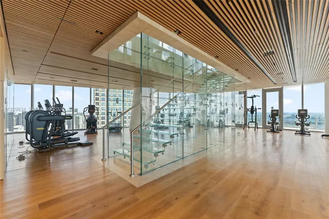 a view of empty room with wooden floor and floor to ceiling window