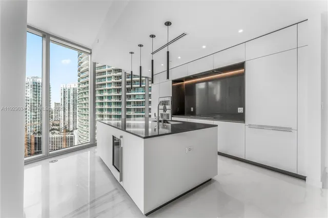 a kitchen with stainless steel appliances granite countertop a stove and a large window