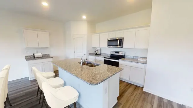a kitchen with white cabinets and stainless steel appliances