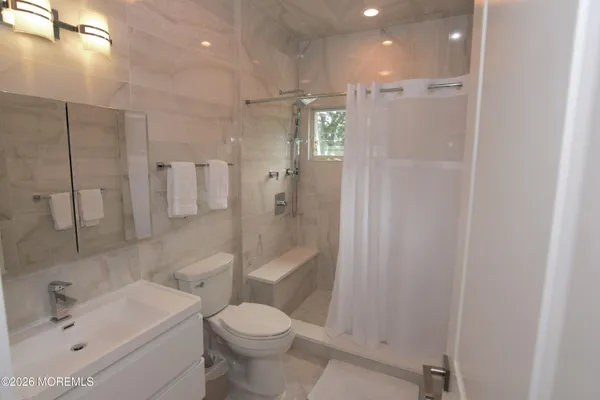 a bathroom with a sink a toilet and shower