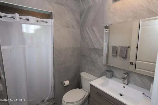 a bathroom with a sink mirror vanity and toilet