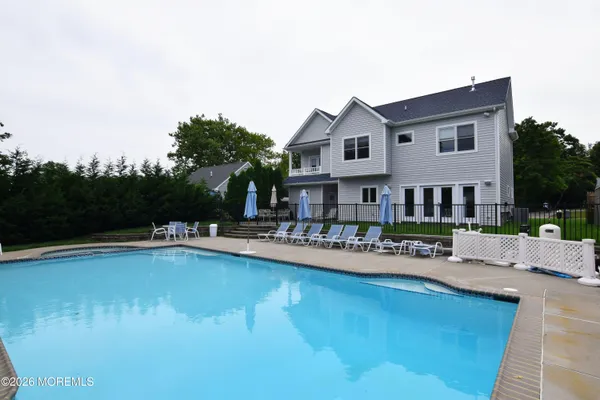 a front view of a house with swimming pool having outdoor seating