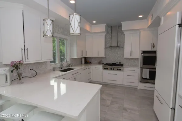 a kitchen with stainless steel appliances granite countertop a sink a stove and a refrigerator