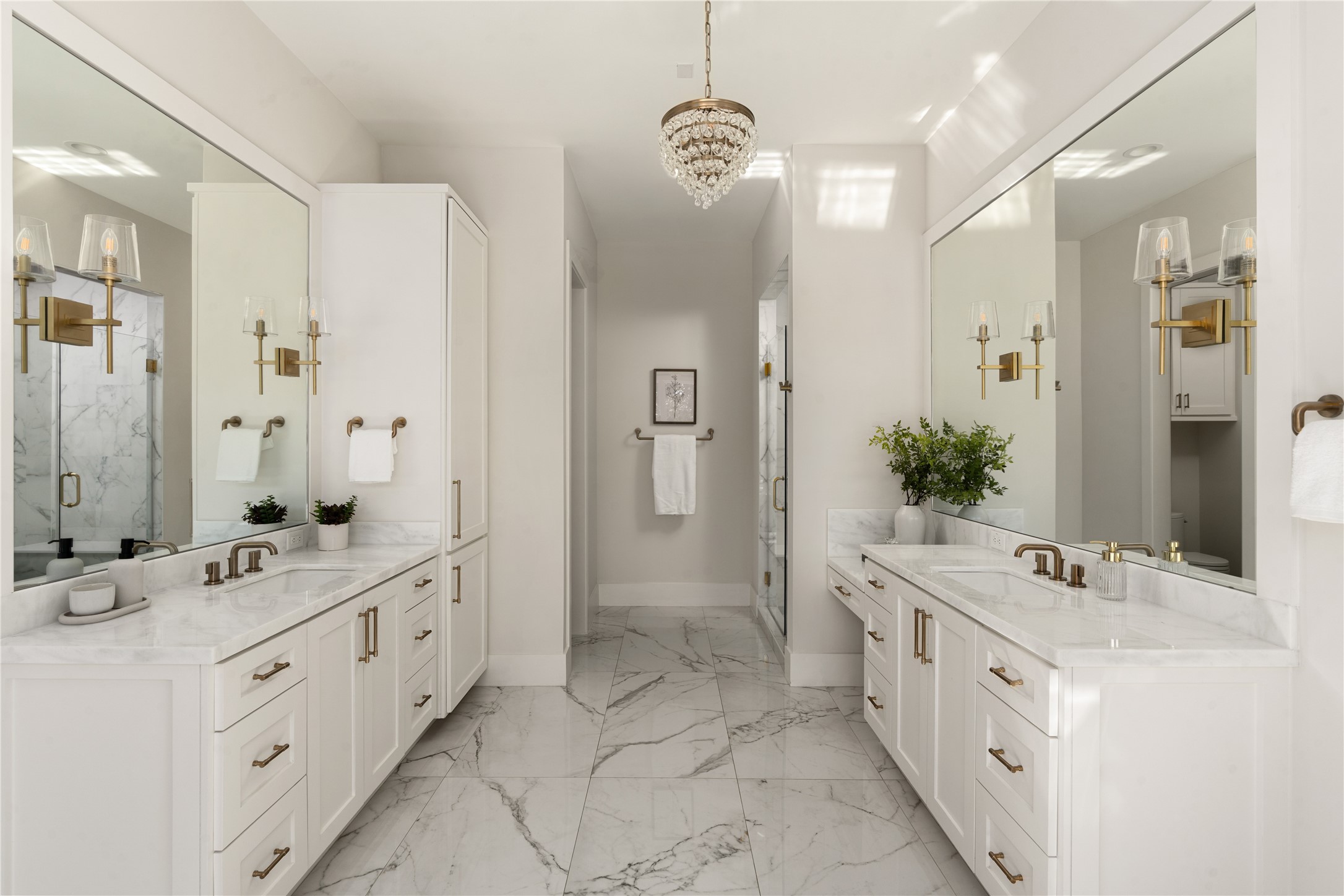 2715 Robinhood Street Houston, TX 77005 - Photo 28 of 48 An additional view highlights the spa-like symmetry of the primary bath, featuring dual marble vanities, elegant brass fixtures, and a crystal chandelier that adds a touch of refined luxury.