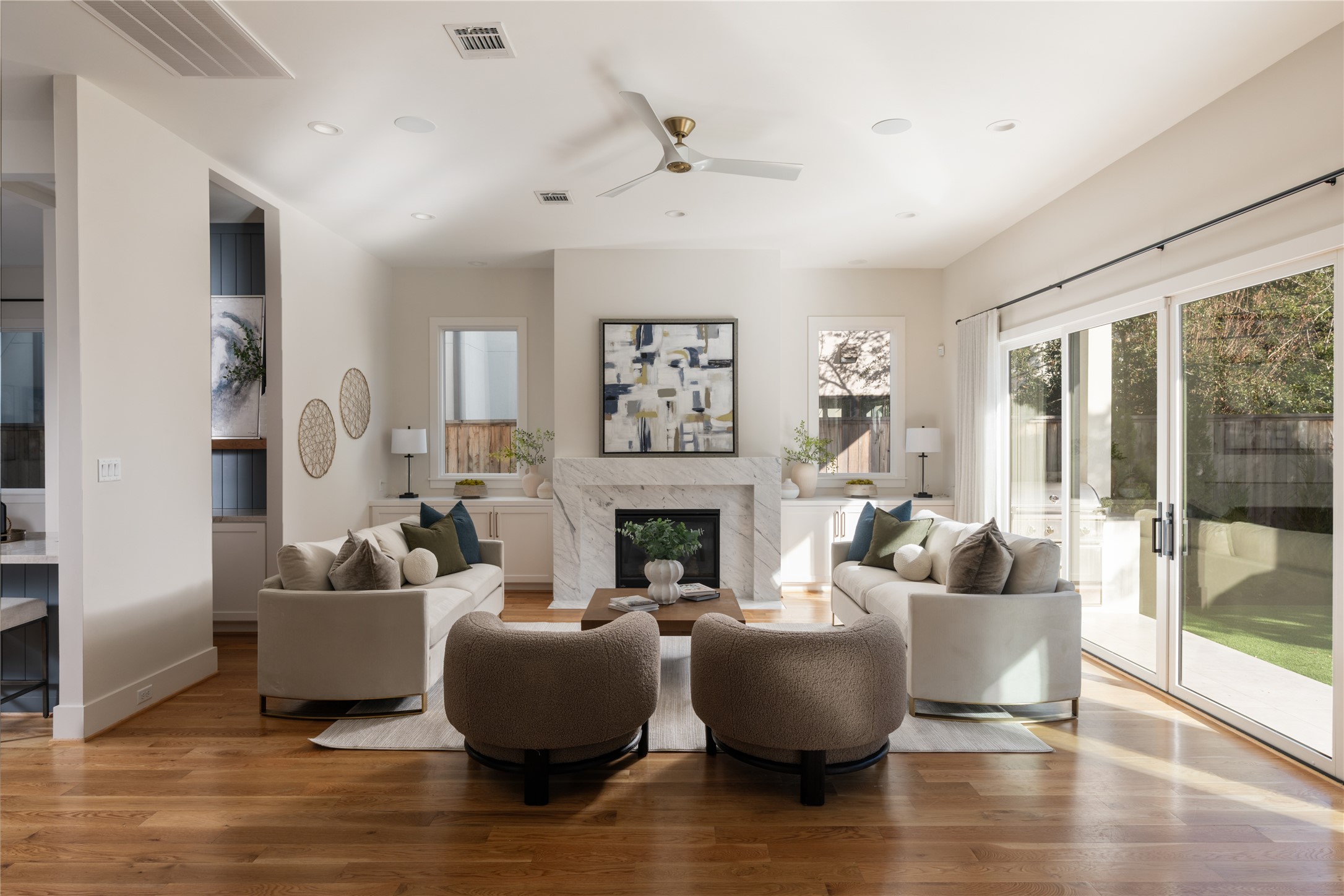 2715 Robinhood Street Houston, TX 77005 - Photo 3 of 48 This inviting living room centers around a sleek marble fireplace, flanked by custom built-ins and anchored by wide-plank hardwood floors. Expansive sliding glass doors flood the space with natural light and create a seamless connection to the outdoor living area.