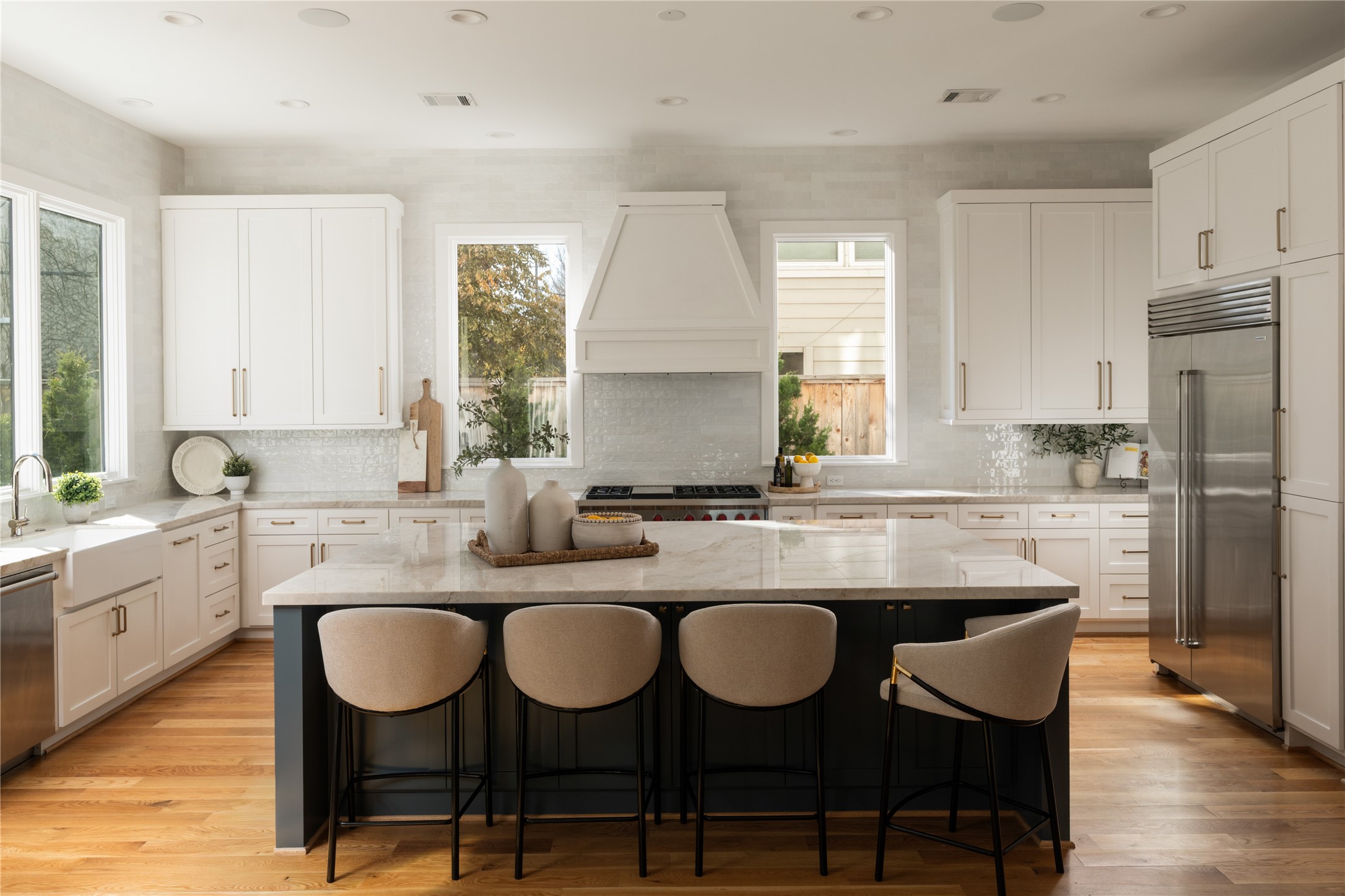2715 Robinhood Street Houston, TX 77005 - Photo 4 of 48 This chef-inspired kitchen impresses with crisp white cabinetry, a dramatic custom vent hood, and an oversized waterfall island anchored by sleek contrasting finishes. Quartz surfaces, premium appliances, and abundant natural light create a space that is both highly functional and beautifully refined for everyday living and entertaining.