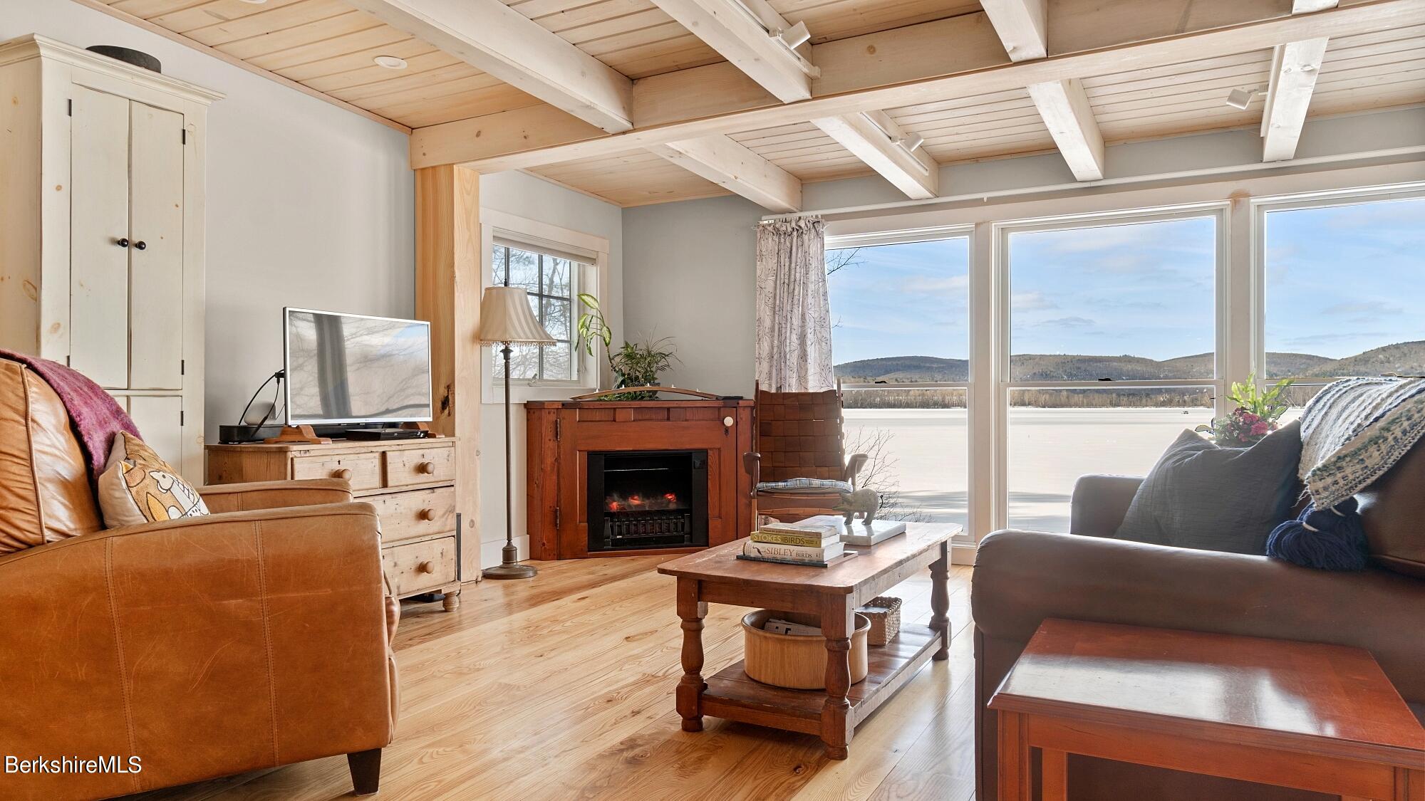 42 Lake Rd Extension Richmond, MA 01201 - Photo 16 of 47 a living room with furniture a fireplace and a floor to ceiling window