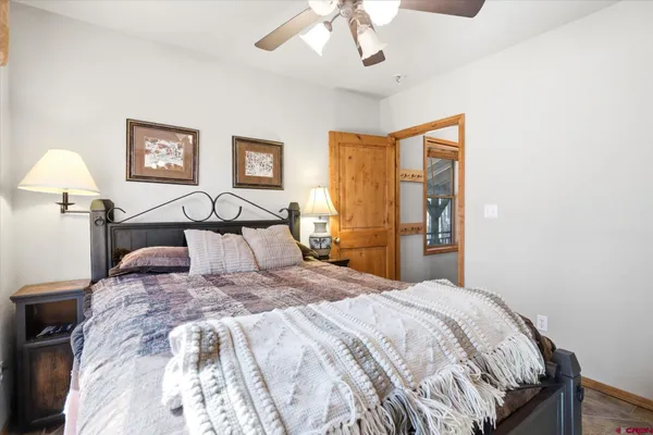 a bedroom with a large bed and a lamp on table
